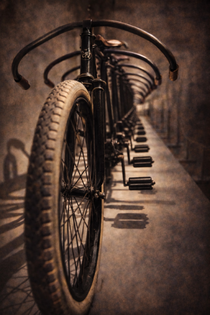 Vintage bicycles lined in a row with repeating handlebars and wheels photographed with shallow depth of field